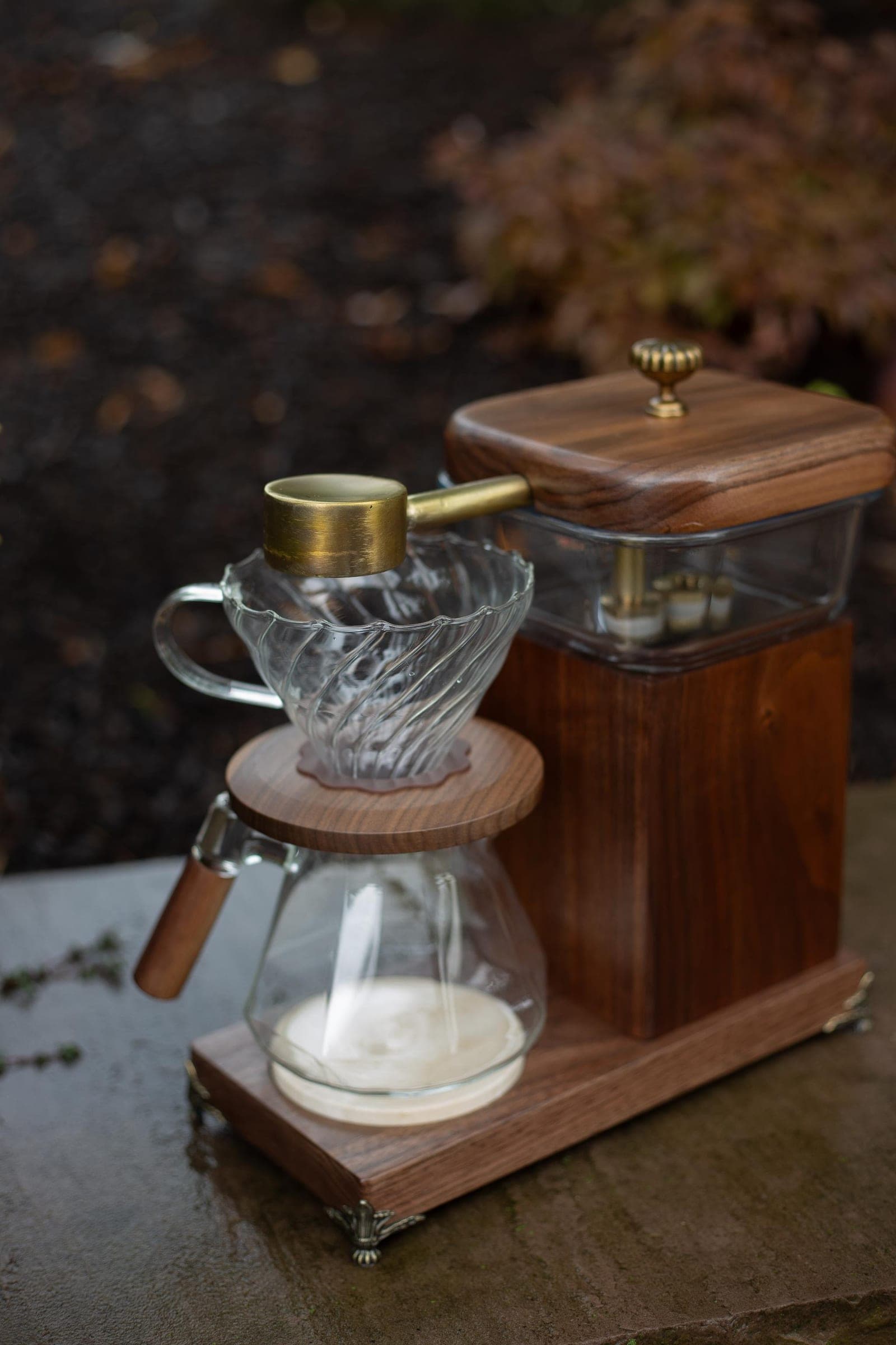 The Heritage Drip out of doors on rain-wet stone, walnut and brass against the autumn garden